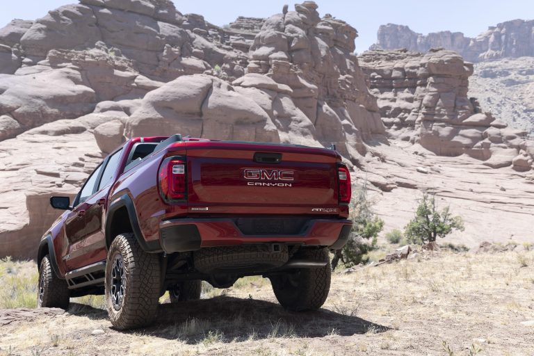 Rear view of GMC Canyon AT4X with Edition 1 package over uneven terrain.