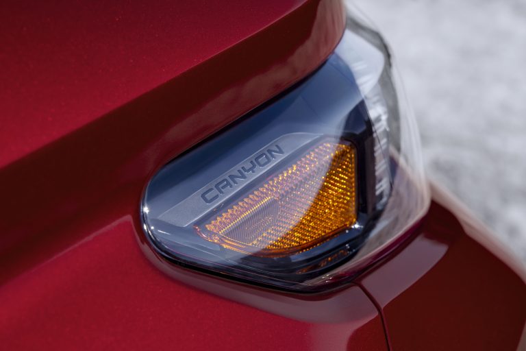 Detail shot of GMC Canyon AT4X with Edition 1 package headlight with Canyon lettering in light.