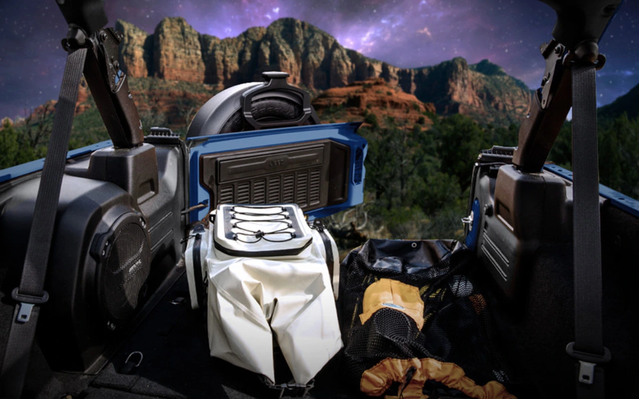 vue de l'espace de la boite d'un Jeep Wrangler 2023, chargé avec de l'équipement de camping sous un ciel étoilé